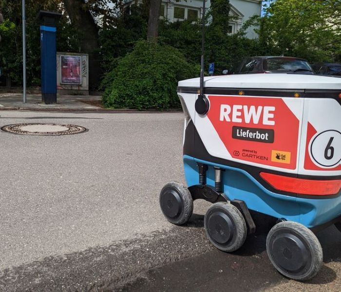 Die Last-Mile-Logistik von REWE wird durch ein KI-gesteuertes Lieferbot unterstützt, das die bestellten Produkte direkt an die Haustür liefert. (Foto: REWE.)